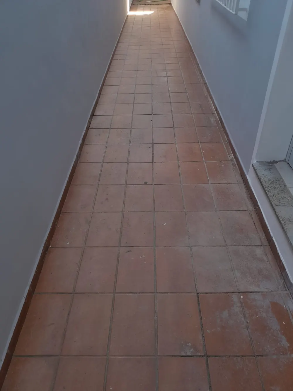 Corredor externo com piso cerâmico antes da revitalização