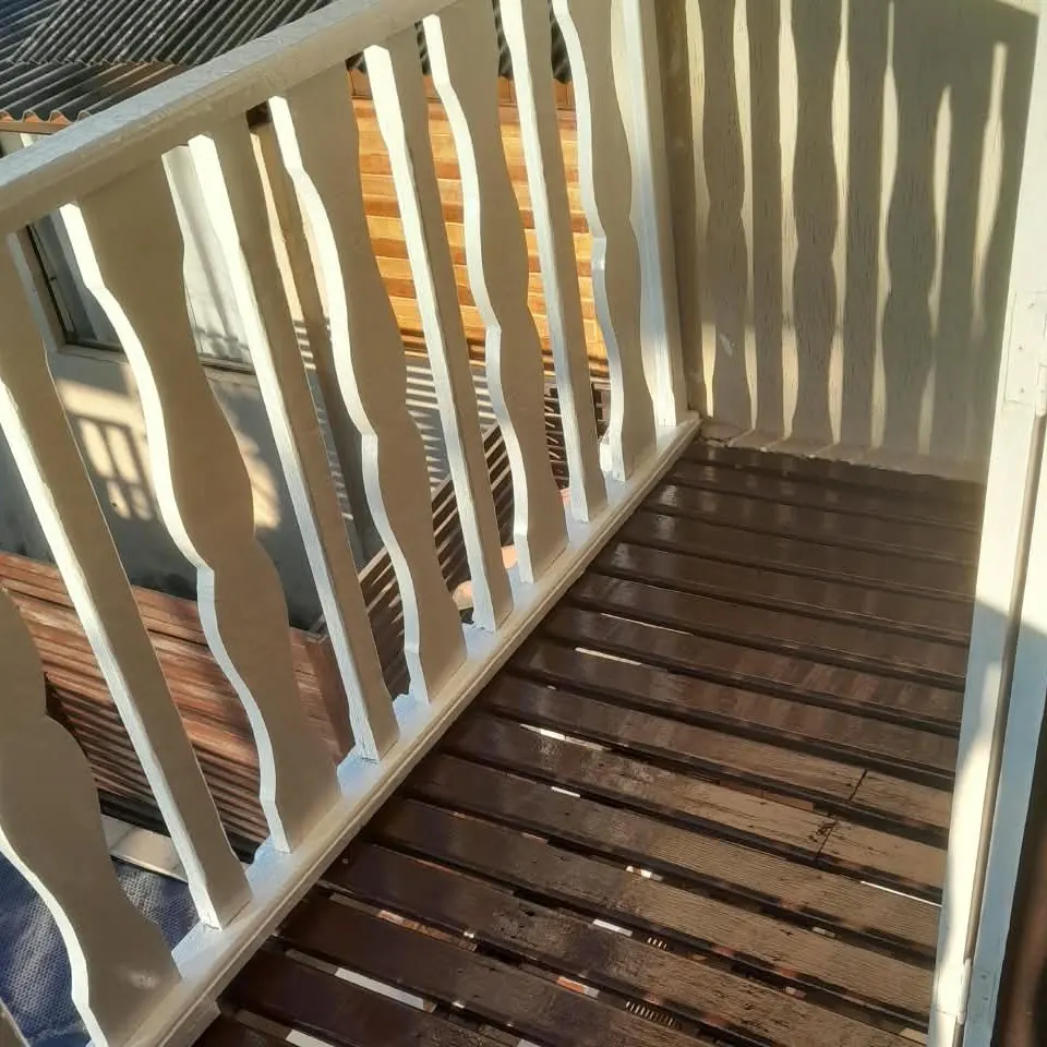 Sacada de madeira com guarda-corpo pintado e deck envernizado